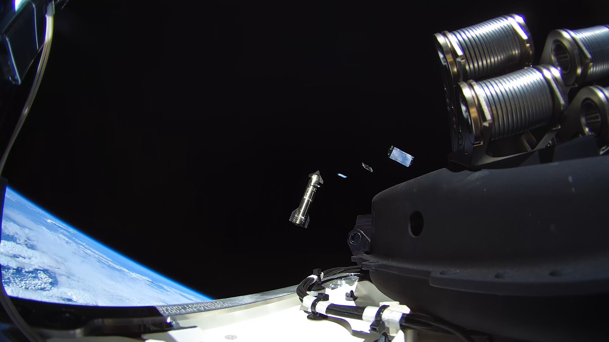 Satélites Starlink V3 se afastando do compartimento de carga da Starship, com a Terra abaixo
