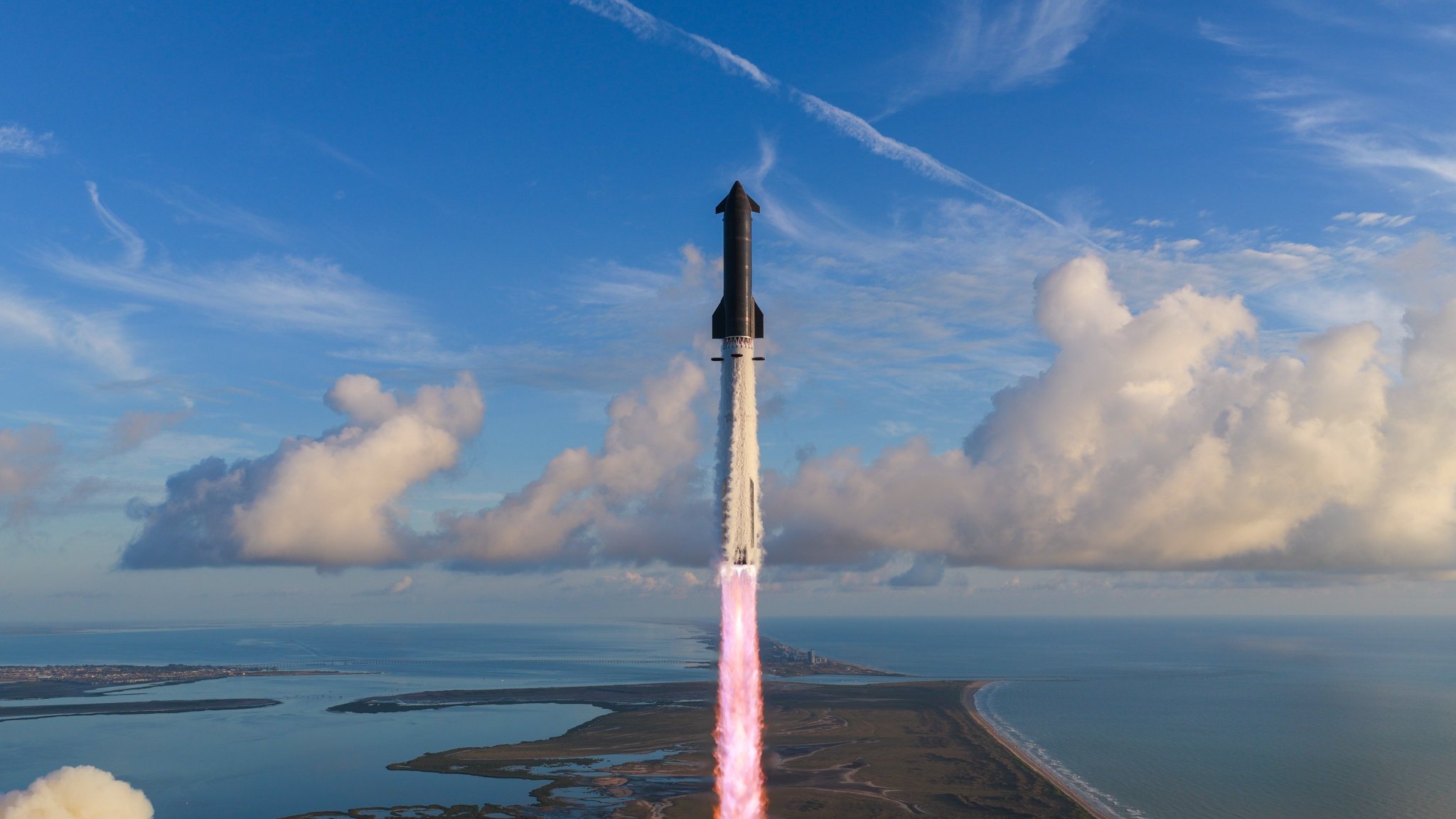Starship subindo sobre o litoral, com o mar e nuvens ao fundo